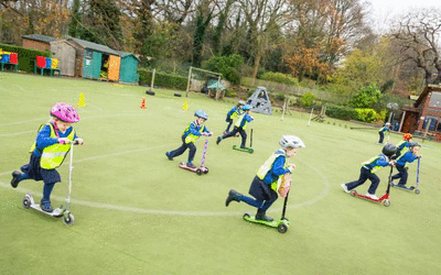 Primary school children driving scooters